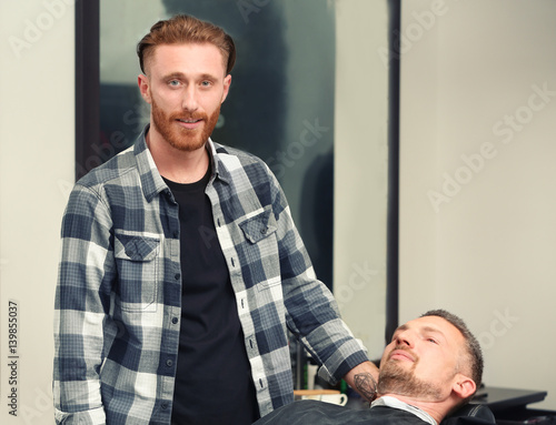 Young bearded hairdresser a...