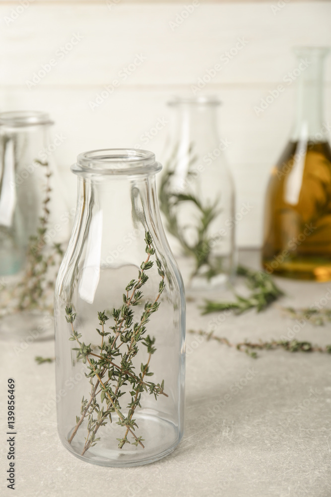 Bottle with thyme on table