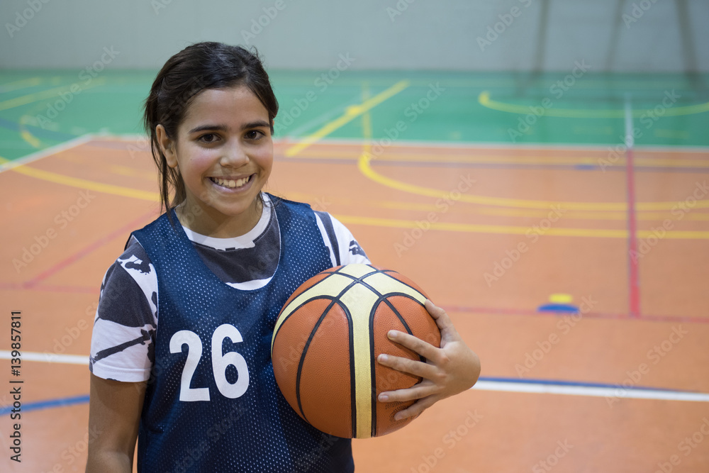 Naklejka premium Mixed race girl holding basketball