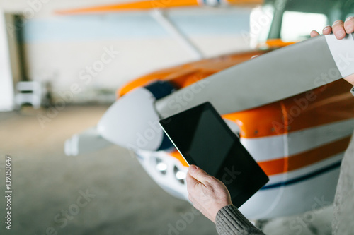 Flight instructor inspecting small Piper aircraft