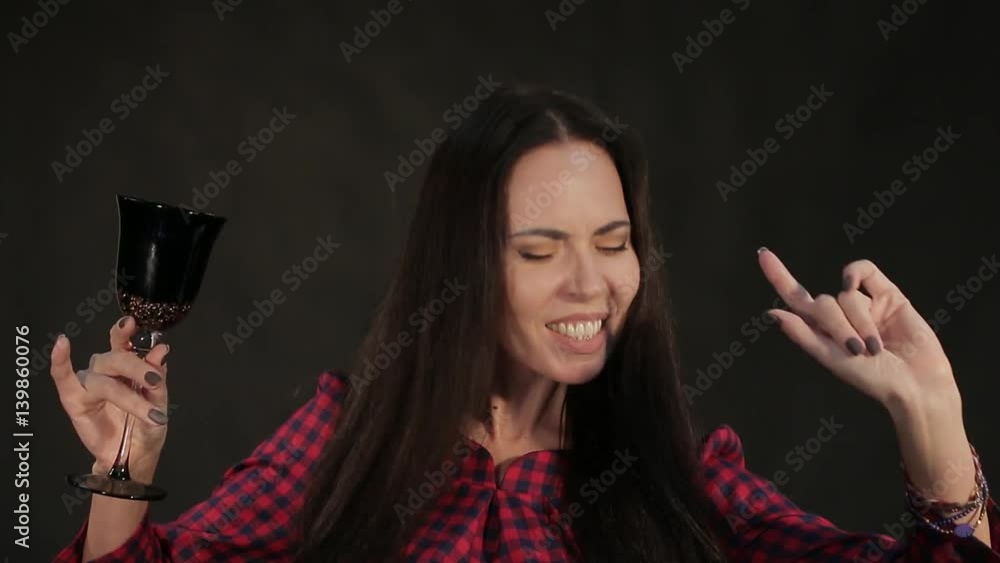 Girl is dancing with a glass, on a black background Girl is dancing with a glass, on a black background