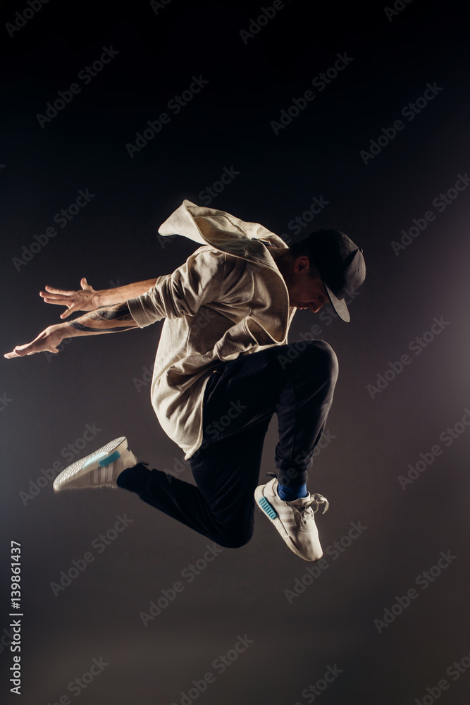 Obraz premium Jumping young male dancer on grey background