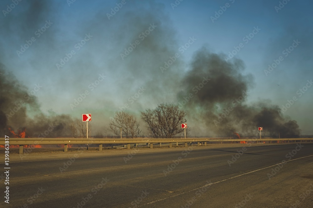 Burning steppe along the road. Burns dry grass.  