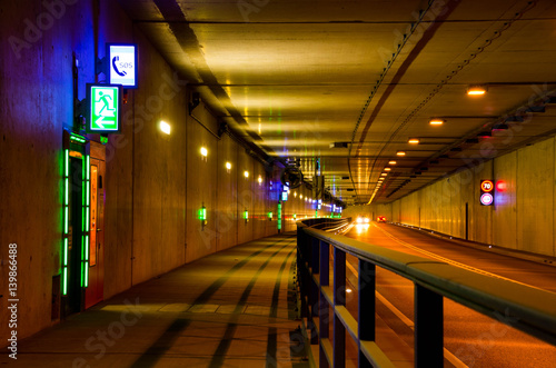Car driving through a tunnel with speed limit 70 kmph. Emergency exit in a tunnel