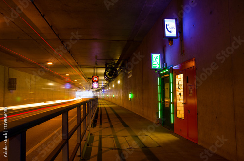 Car driving through a tunnel with speed limit 70 kmph. Emergency exit in a tunnel