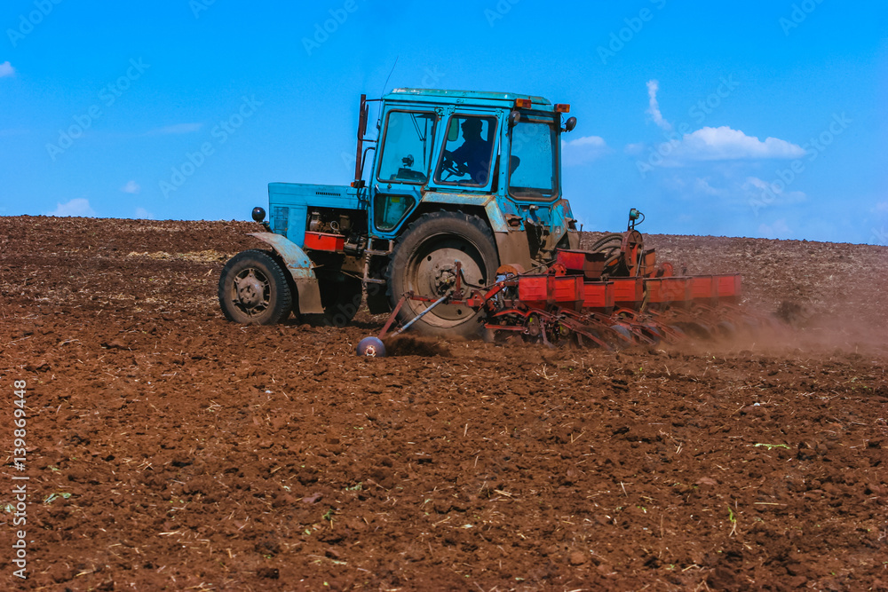 Tractor cultivating field at spring. Russian agriculture Tractor cultivating field at spring. Russian agriculture