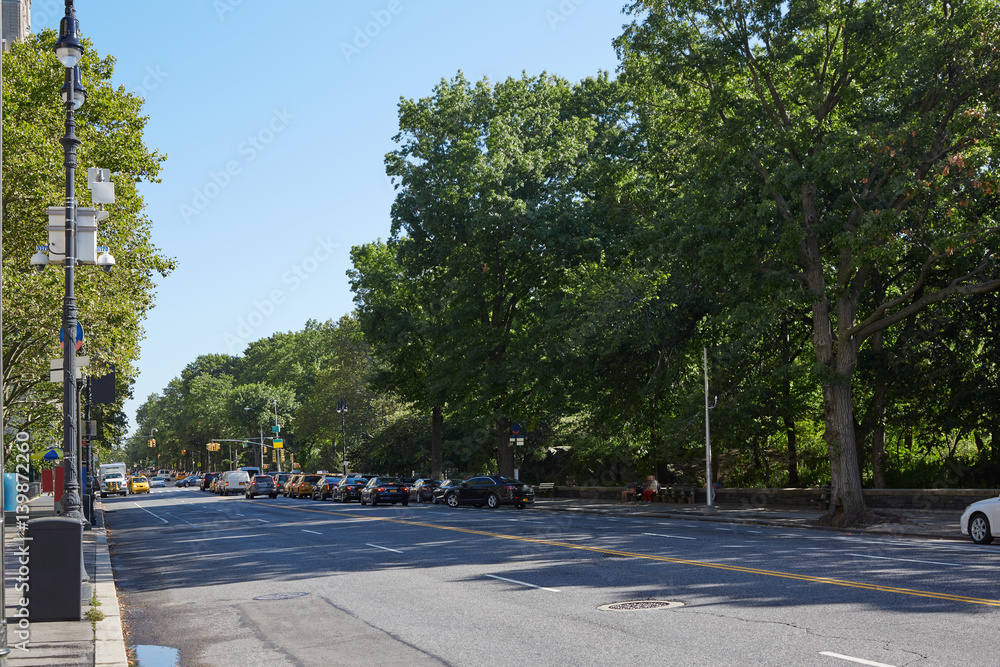 New York empty street near Central Park, green trees in a sunny day