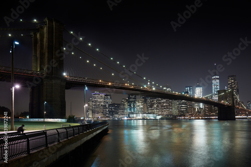 Fototapeta Naklejka Na Ścianę i Meble -  Brooklyn Bridge and New York city skyline illuminated at night with docks