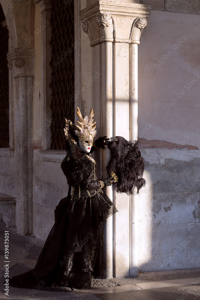 Fototapeta premium Aristocratic appearance: Venetian mask, noble costume, black velvet, golden headdress - Carnival in Venice