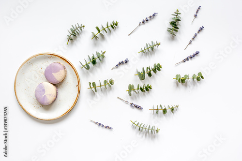 woman table with macaroons lavander and eucalyptus top view