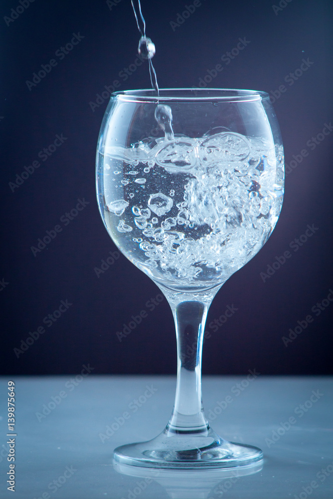 Pure water pouring into a transparent glass Pure water pouring into a transparent glass