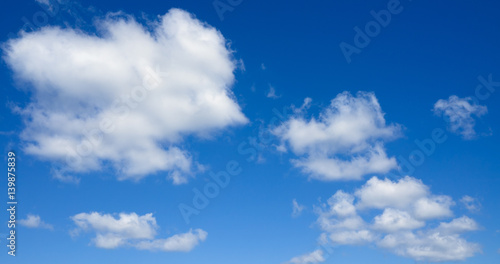 Panorama of white clouds flying against blue sky.