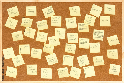 Many stickers for notes with text on the cork board