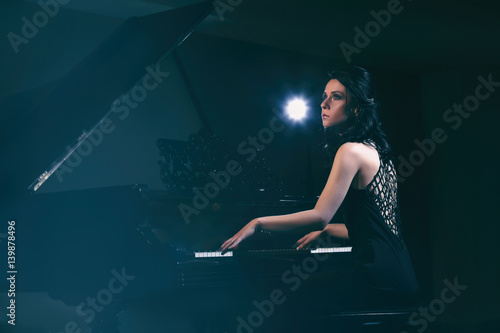 Beautiful woman playing pia...