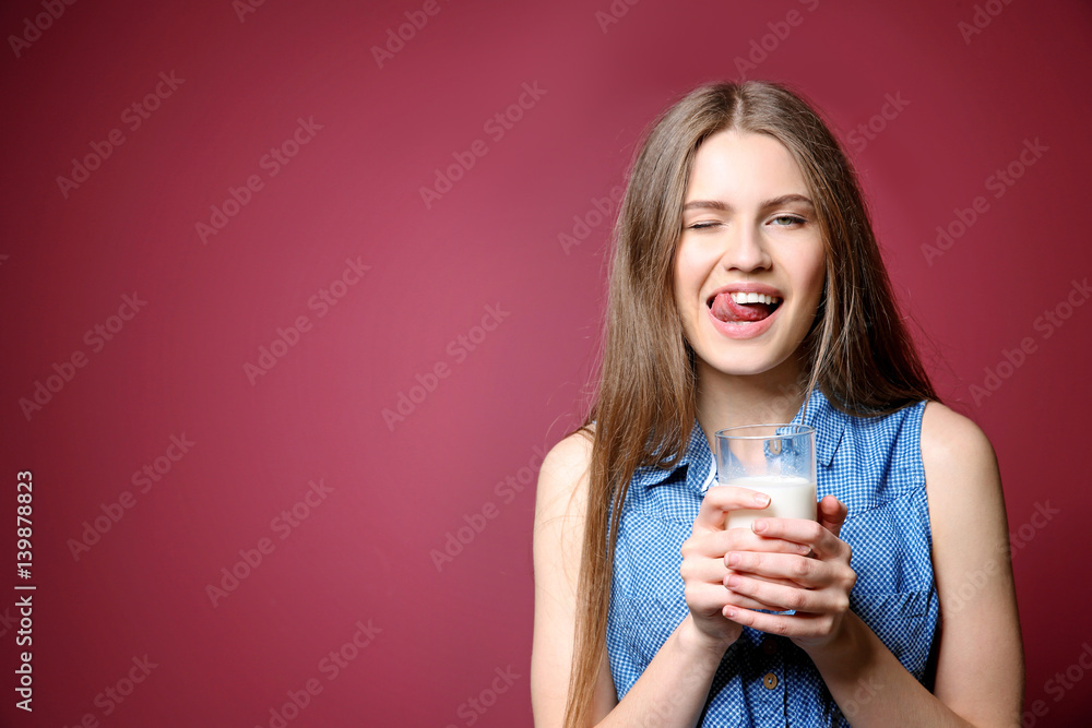 Beautiful young woman with glass of milk on color background Beautiful young woman with glass of milk on color background