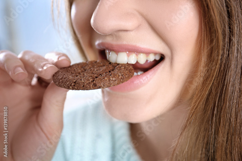 Young woman eating cookie  closeup