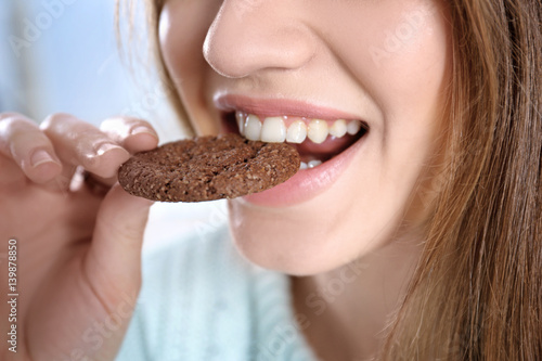 Young woman eating cookie, ...
