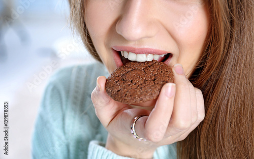 Young woman eating cookie, ...