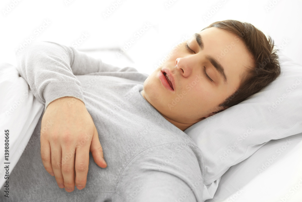 Tired young man sleeping in bed at home Tired young man sleeping in bed at home