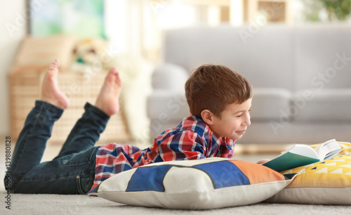 Little boy reading book on ...