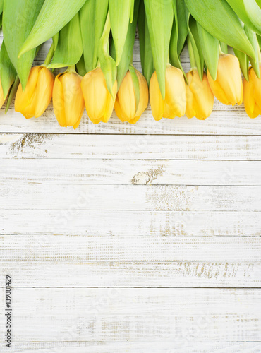 Fototapeta Naklejka Na Ścianę i Meble -  Yellow tulips over wooden background