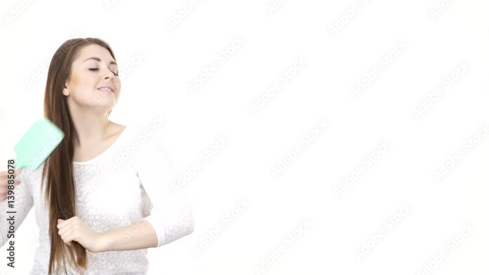 Woman combing her healthy hair with brush. Young latin female with beautiful natural brown straight long hairs -studio shot isolated on white background 4K ProRes HQ codec Woman combing her healthy hair with brush. Young latin female with beautiful natural brown straight long hairs -studio shot isolated on white background 4K ProRes HQ codec