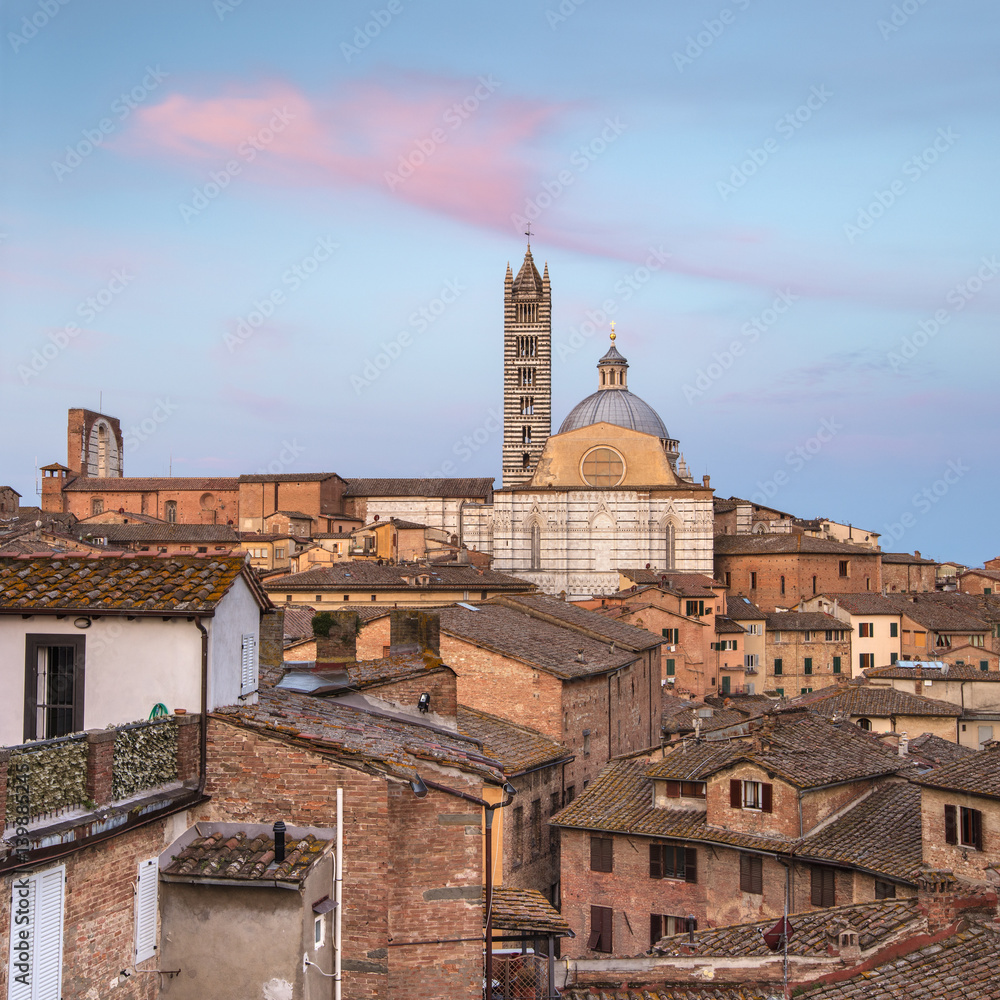pink cloud above the towers of cathedral in Siena in Tuscany in Italy