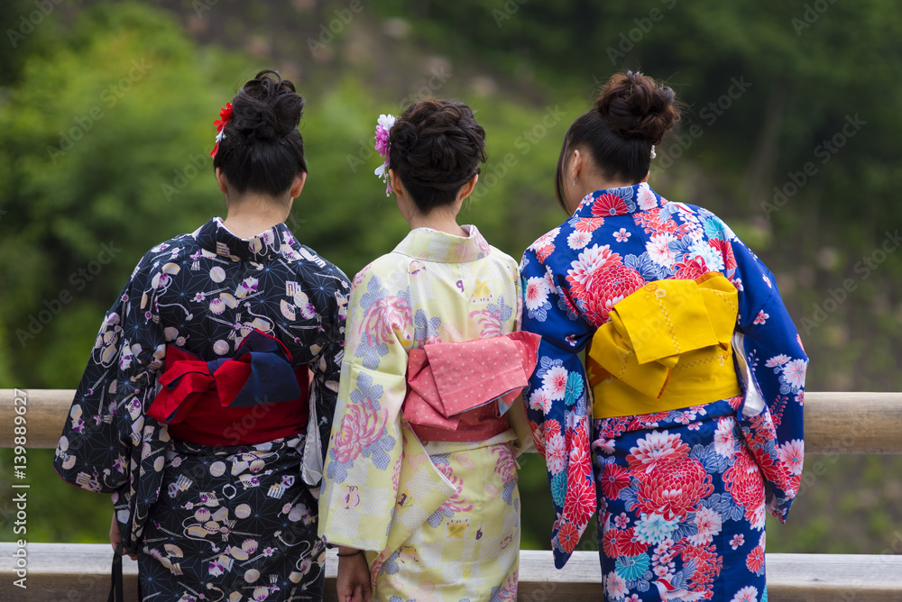 Fototapeta premium KYOTO, JAPAN - NOVEMBER 25 2015: Women tourism wear a traditional dress called Kimono for travelling in Kyoto on November 25 2015.