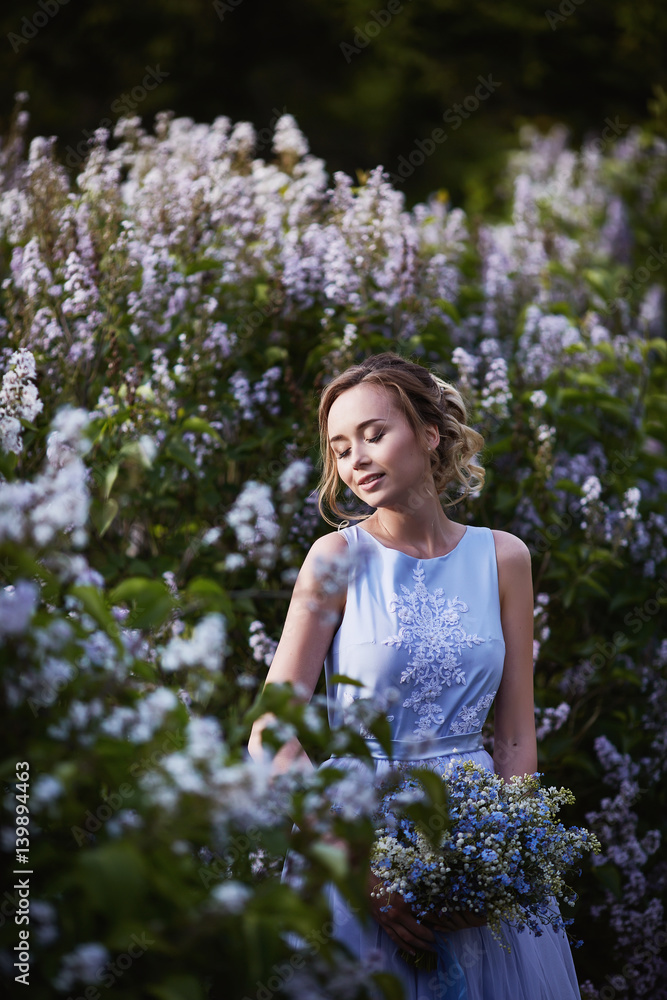 Girl with a lilac bouquet of lilac in the garden Girl with a lilac bouquet of lilac in the garden
