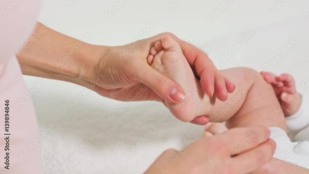 mother massaging little baby's feet with oil mother massaging little baby's feet with oil