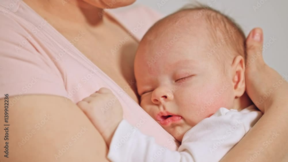 Beautiful baby in her mothers hands falling asleep Beautiful baby in her mothers hands falling asleep