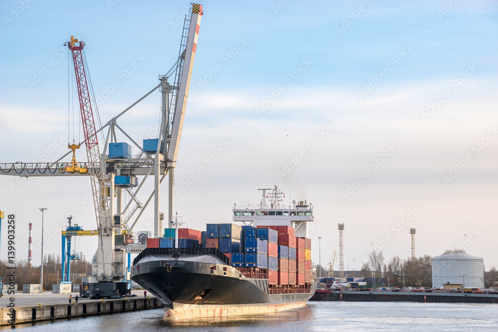 Szczecin ,Poland-January 2017:sea container flows into port for unloading harbor cranes and gantries Szczecin ,Poland-January 2017:sea container flows into port for unloading harbor cranes and gantries