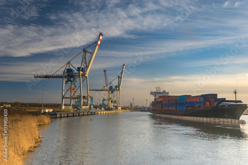 Szczecin ,Poland-January 2017:sea container flows into port for unloading harbor cranes and gantries photo