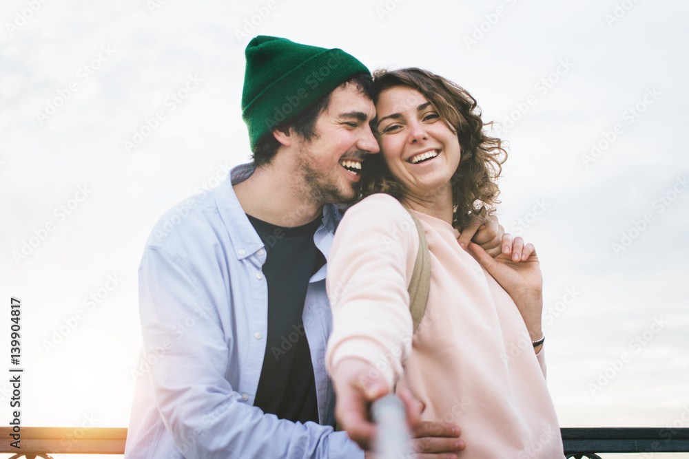 Lovers man and woman taking selfie with selfie stick Lovers man and woman taking selfie with selfie stick