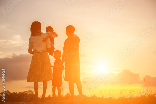 silhouette of happy family father mother and son playing outdoors at sunset