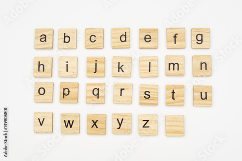 Lowercase alphabet letters on scrabble wooden blocks, isolated on white background