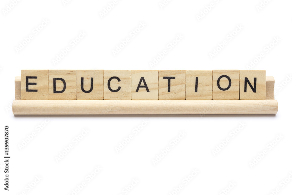 Word ''education'' on scrabble wooden letters on a rack, isolated on white background. Stock