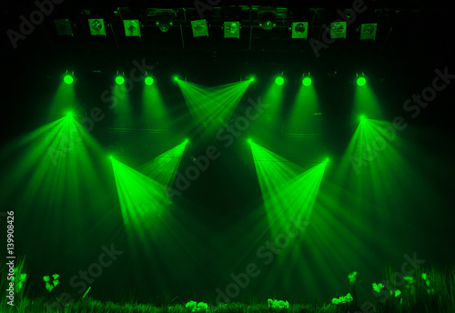 The green light from the spotlights through the smoke in the theatre during the performance. Lighting equipment.