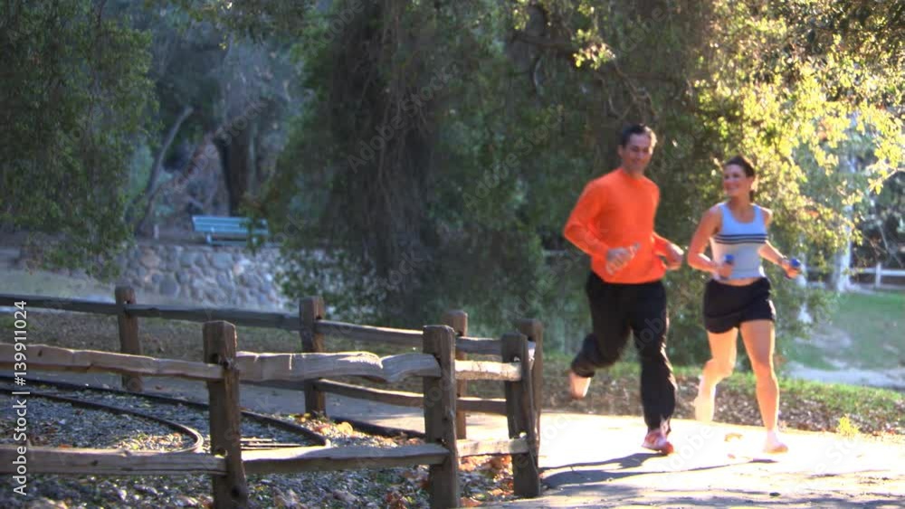 Couple running by a rail fence Couple running by a rail fence
