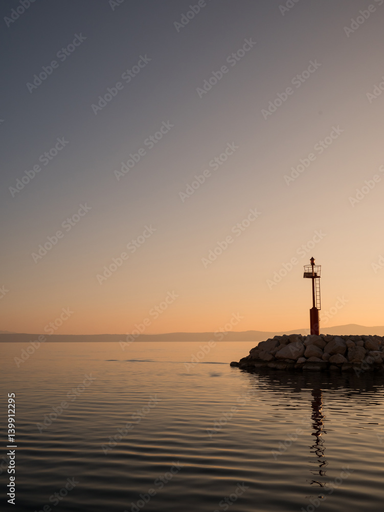 Calm sea and red lighthouse tower