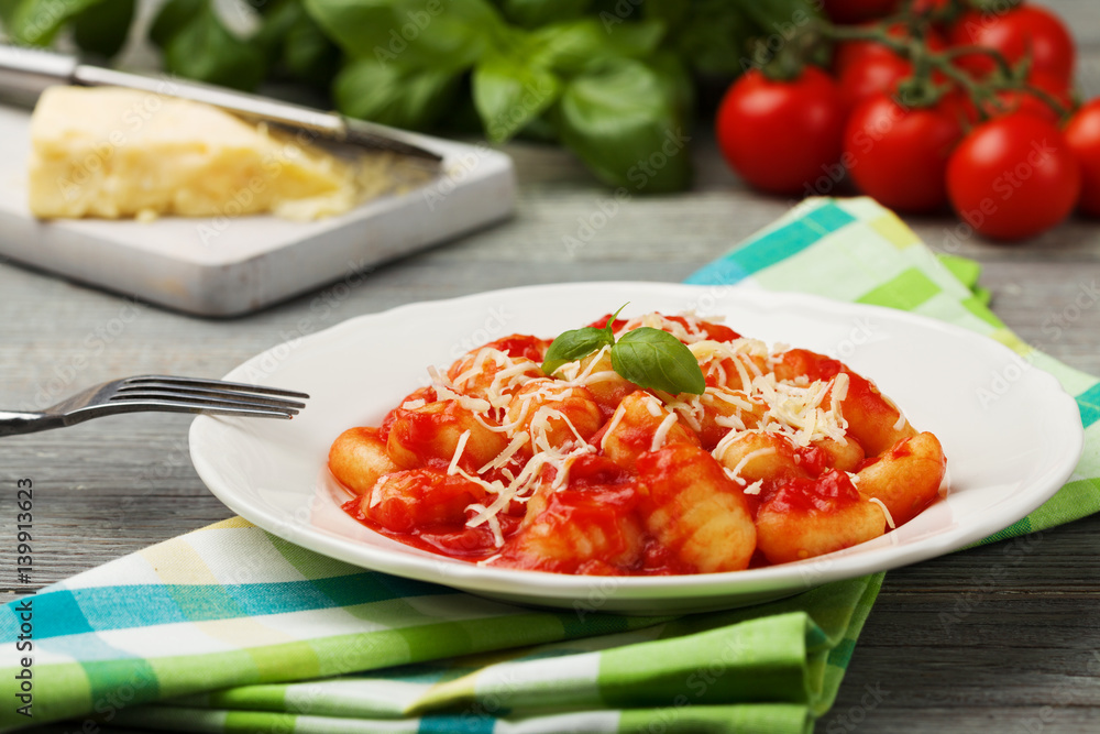 Serving gnocchi in tomato sauce with cheese. Serving gnocchi in tomato sauce with cheese.