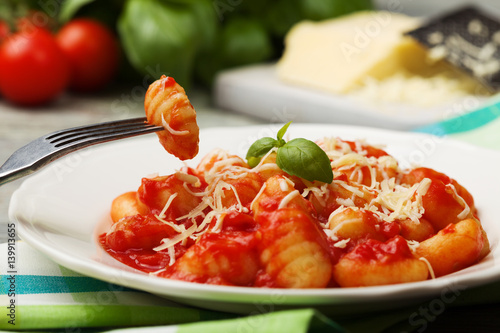 Bild auf Leinwand Serving gnocchi in tomato sauce with cheese.