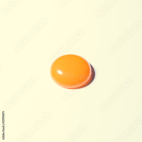 Egg yolk on bright background. Minimal Easter concept. photo