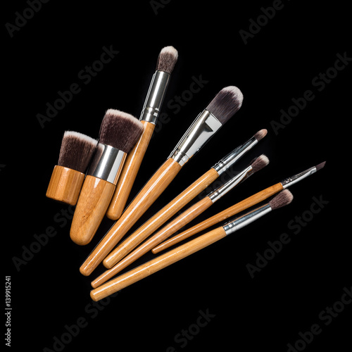 Collection of professional makeup brushes on black background