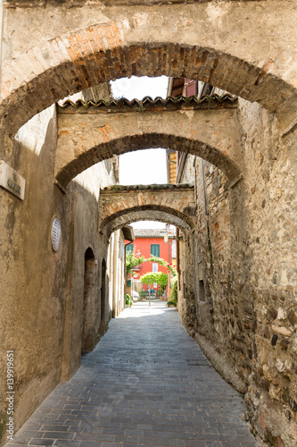 Picturesque narrow town street in Sirmione, Lake Garda Italy.