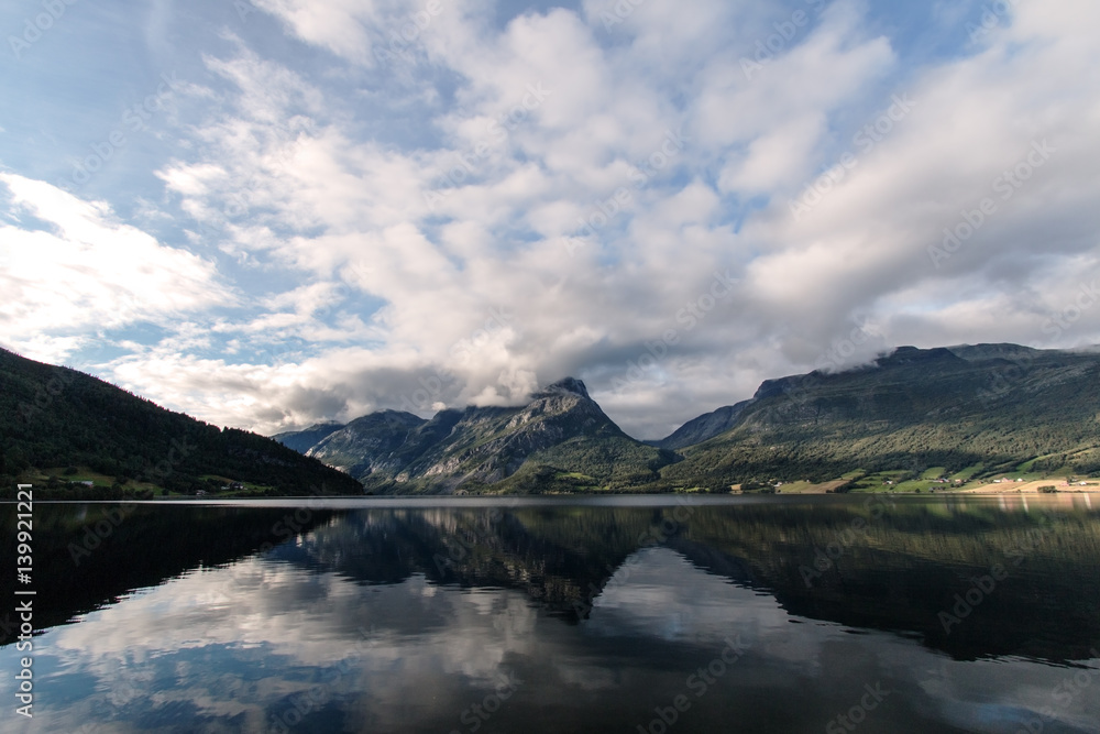 Reflection clouds and mountains on lake Vang in Norway