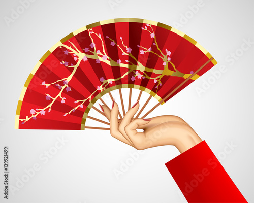 Woman's hand with open chinese red fan isolated on white