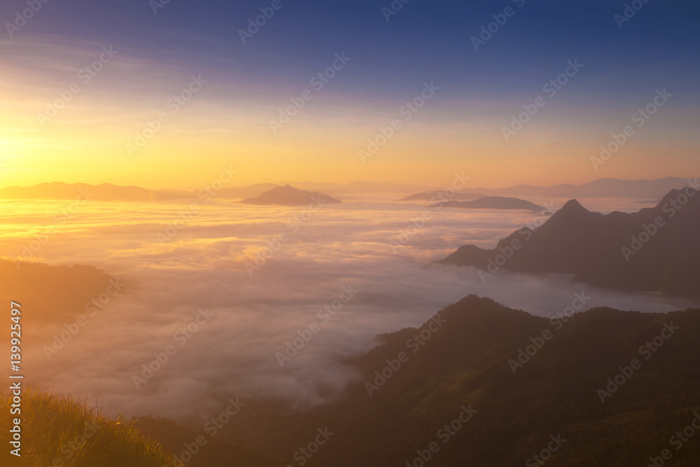 Dreamy sunrise on the top of the mountain with the view into misty valley. Beautiful day in nature.