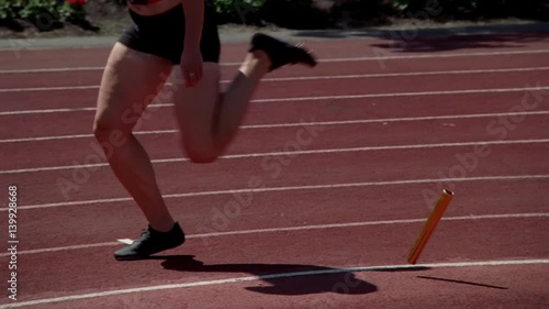 Woman relay racer dropping the baton, switch from real-time to slow motion photo