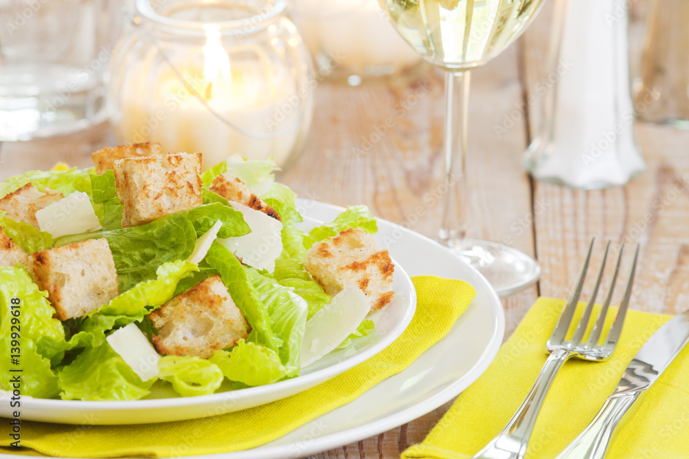 Fresh Caesar salad on a rustic table in bright light